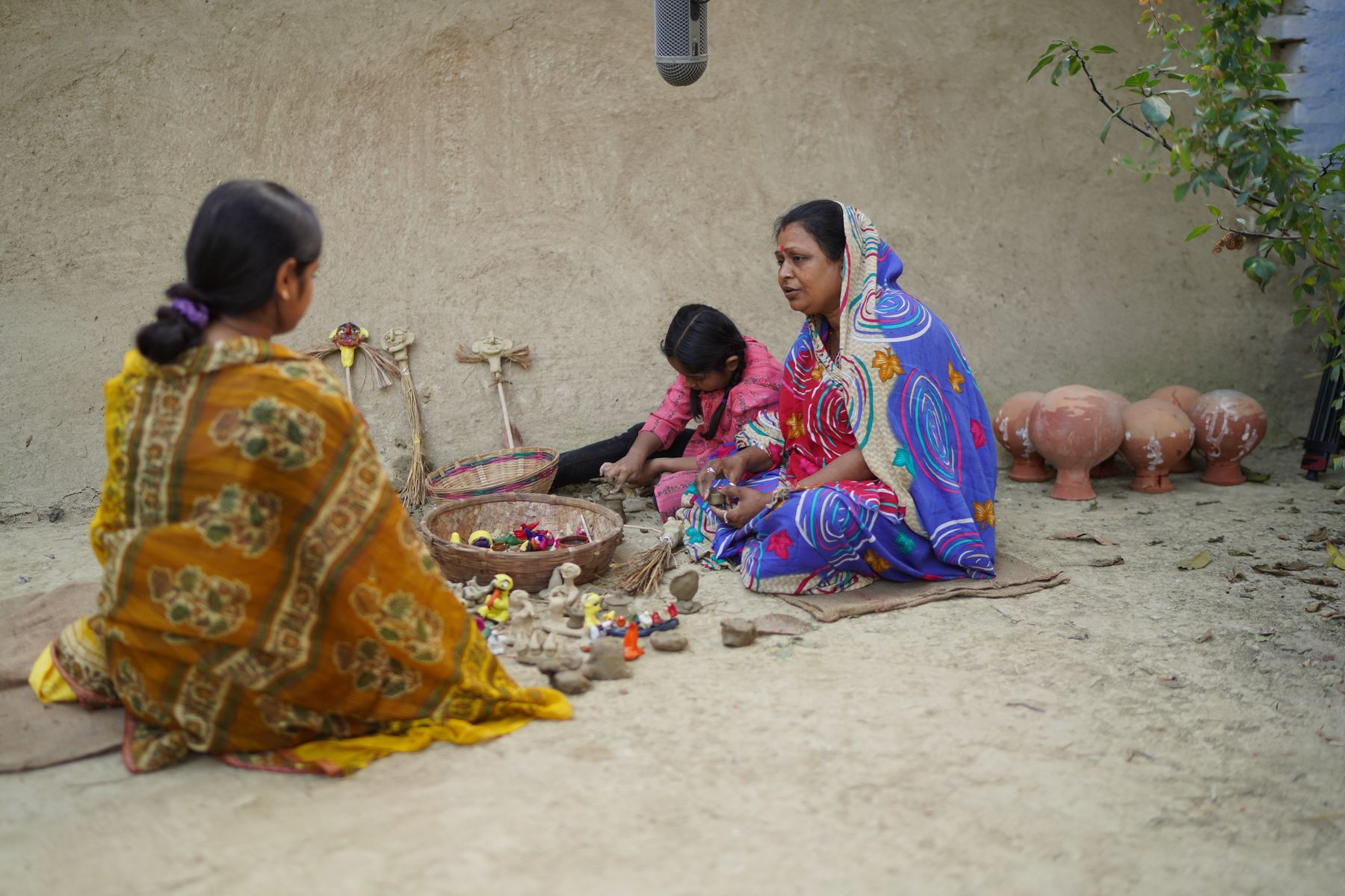 Grandmother and granddaughter with clay figurines